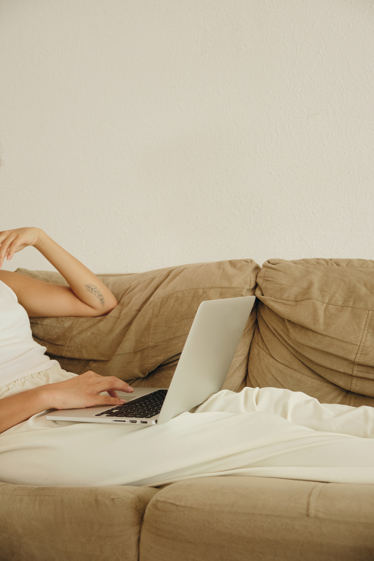 Woman Using a Laptop on the Sofa